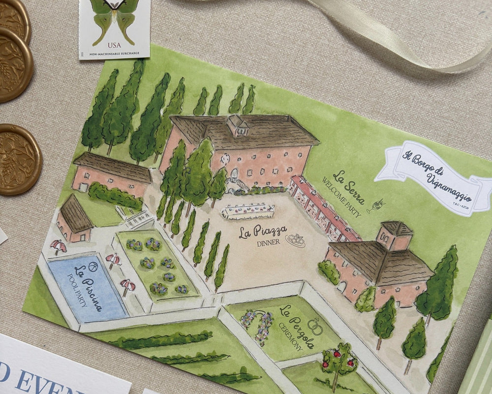 Watercolor map of an Italy wedding venue with venue details on paper and various wedding stationery supplies on a textured surface