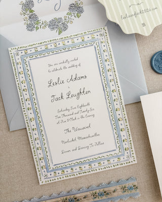 Wedding invitation card with decorative border on a textured surface